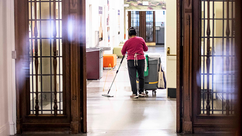 A member of the Facilities staff mopping in the hallway