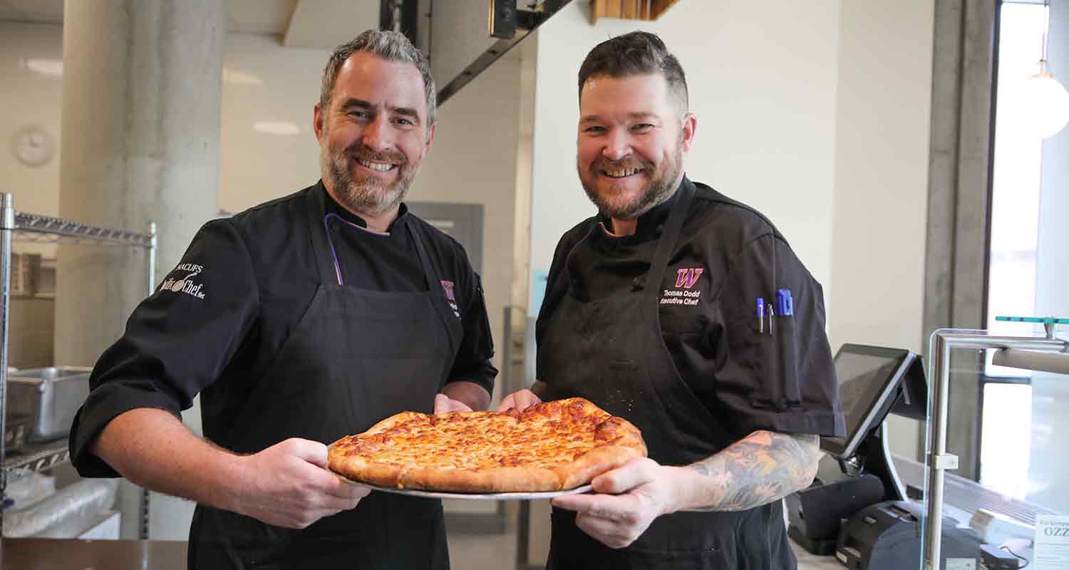 UW Dining Chefs Eliot and Thomas show off an original cheese pie from Dawg House Pizza.