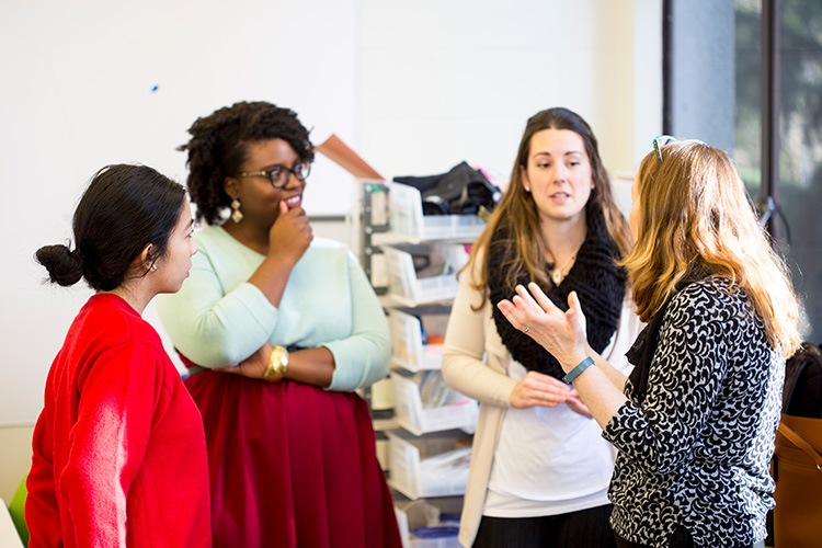 Three students speaking with a faculty member from The Humanities Academic Services team.