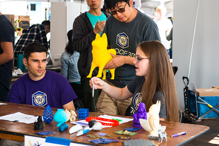 Three students working on 3-D printed crafts in The MILL.