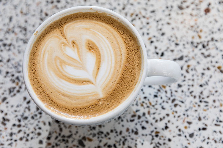 Aerial image of a latte that has a leaf drawn in the foam.